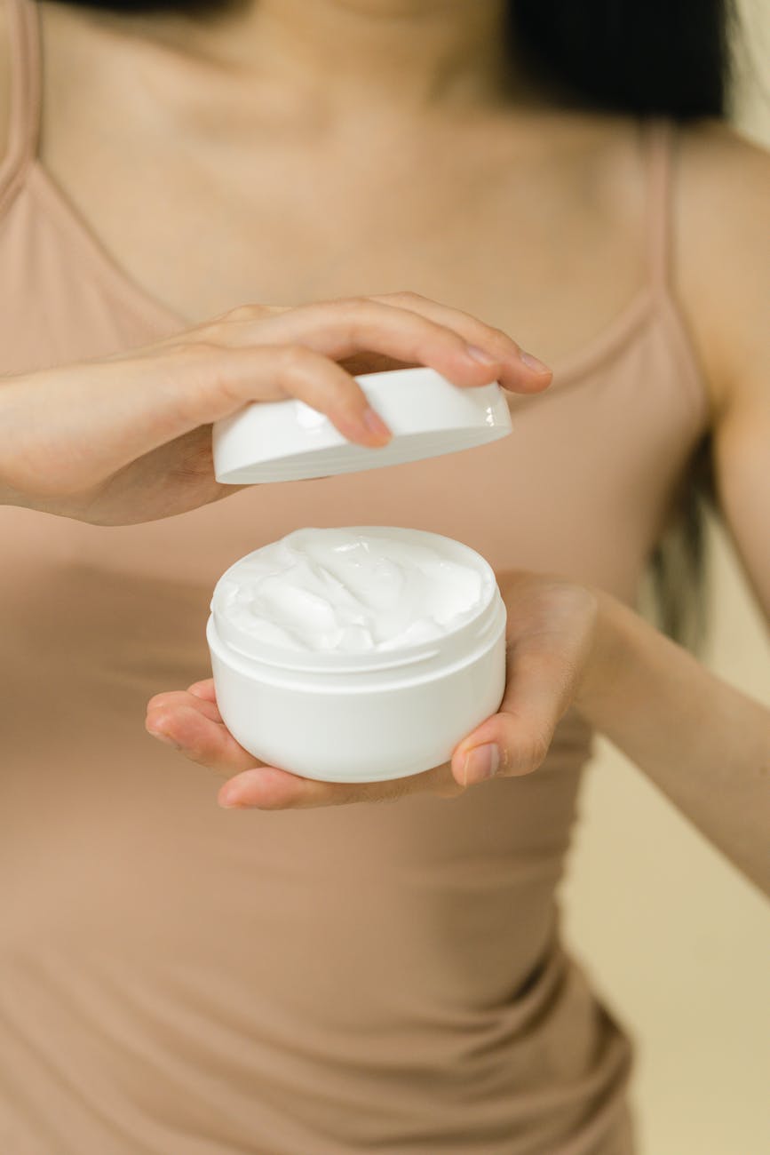 a female hands holding an opened cosmetic cream